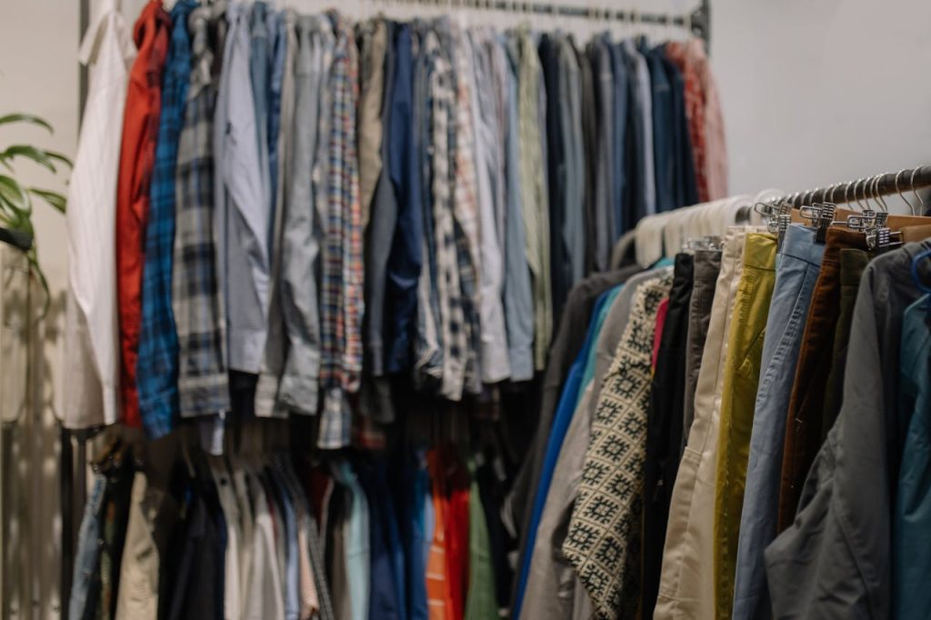 pexels-photo-6068952-1 Assorted clothing on racks in a thrift shop, showcasing various styles and colors.